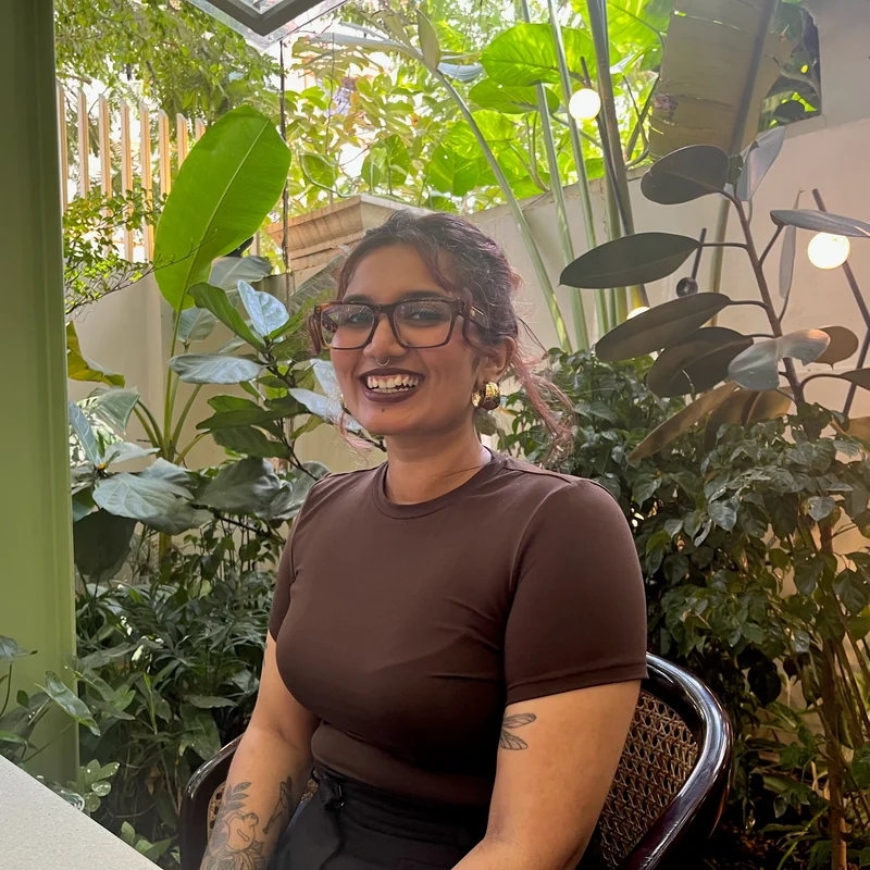 Aparna Bindu Dilip seated among plants